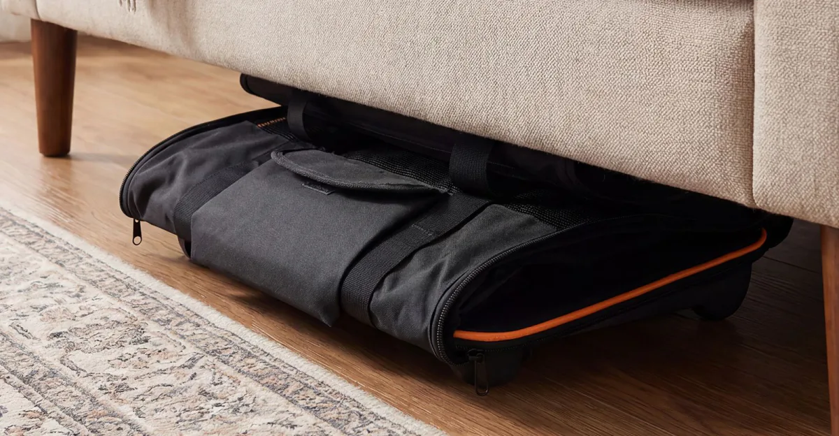 The carrier folded flat and stored under a sofa
