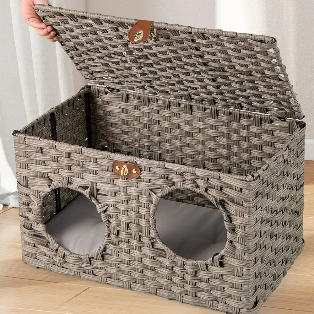A hand lifting the woven lid to show the grey cushion inside